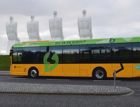 Bybus med de fire hvide mænd i baggrunden 